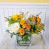Yellow and white flower arrangement in a square glass vase