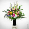 Tall mixed flower arrangement in a black vase with pink roses and a sunflower
