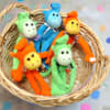 Basket of colorful plush monkey toys on a polka dot background