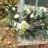 Mixed bouquet in a metal container with white, blue, and green flowers