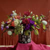 Colorful mixed bouquet in a black skull-patterned container