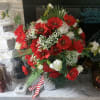 Bright, bold clusters of red poppy-like blooms explode against crisp white roses