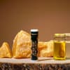 Portland Bee Balm tube beside amber crystals and small glass jars of oil