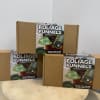 Three cardboard boxes of foliage funnels stacked on a round pedestal.
