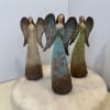 Three angel figurines standing on a round marble base