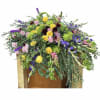 Large mixed floral arrangement with yellow roses, purple blooms, and pink flowers