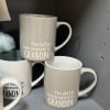 Gray ceramic mugs with the text "This dad has been promoted to GRANDPA"
