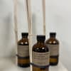 Amber reed diffuser bottles with black caps and reed sticks