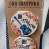 Packaged set of two round car coasters with floral guitar designs