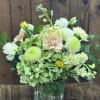 Bouquet of pale green and white flowers in a clear glass vase