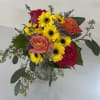 Bouquet of yellow daisies and pink roses in a clear vase