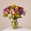 Mixed bouquet of colorful flowers in a clear glass vase
