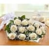 Wrapped bouquet of white roses with baby's breath lying on a wooden surface
