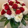 Arrangement of red roses and white hydrangeas in a clear glass vase