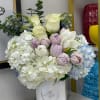 White and pastel flower arrangement in a white vase