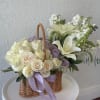 Basket of cream and lavender roses with white lilies and ribbon