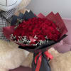 Bouquet of red roses wrapped in black and burgundy paper