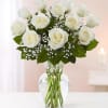 White roses in a clear glass vase with baby's breath