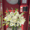White lilies and daisies arranged in a green vase