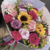 Bouquet of pink and purple roses with sunflowers in pastel wrapping
