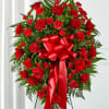 Standing wreath of red roses and carnations with a large red bow