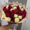 Bouquet of red and cream roses wrapped in pink paper