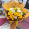 Bouquet of yellow and white roses wrapped in orange paper