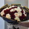 Bouquet of red and white roses wrapped in black paper with gold trim