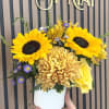 Two bold sunflowers take center stage in this cheerful birthday bouquet, their