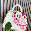 A compact, handbag-shaped floral arrangement that reads like a little luxury gift-soft
