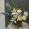 Cool, elegant and quietly dramatic-this basket arrangement brings together white lilies and