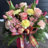 Pink and yellow bouquet in a magenta vase with plaid ribbon