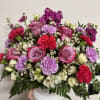 Pink and lavender flower arrangement in a white vase