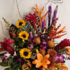 Colorful tropical bouquet with sunflowers, lilies, orchids, and orange bird-of-paradise
