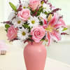 Pink roses and lilies in a pink vase with white daisies