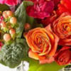 Close-up bouquet of orange and red roses with pink berries