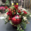 An elegant combination of red flowers, nestled in a bed of Christmas