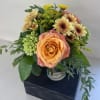 Peach rose bouquet with yellow chrysanthemums in a glass vase
