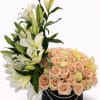 White lilies and peach roses in a black round box with pearl trim