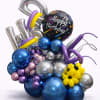 Birthday balloon arrangement with metallic number balloons and a "Happy Birthday" balloon