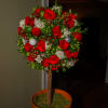 Round arrangement of red roses in a terracotta pot on a stem