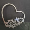 A silver-toned metal heart wall hanger shaped like an open rose silhouette