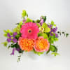 Bright mixed bouquet in a white vase with pink, orange, purple, and green blooms