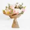 Bouquet of pale pink roses and white hydrangeas wrapped in brown paper