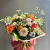 Hand-tied bouquet of orange roses and pale chrysanthemums with airy filler flowers
