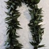 Two dark green leaf garlands arranged in a U shape on a light surface.