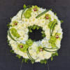 White and green floral wreath on a stand with orchids and chrysanthemums