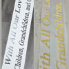 Two printed memorial ribbons with text honoring children and grandchildren.