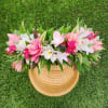 Pink and white floral arrangement in a woven basket