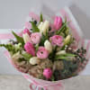 Pink and white mixed bouquet with tulips and ranunculus in striped wrap